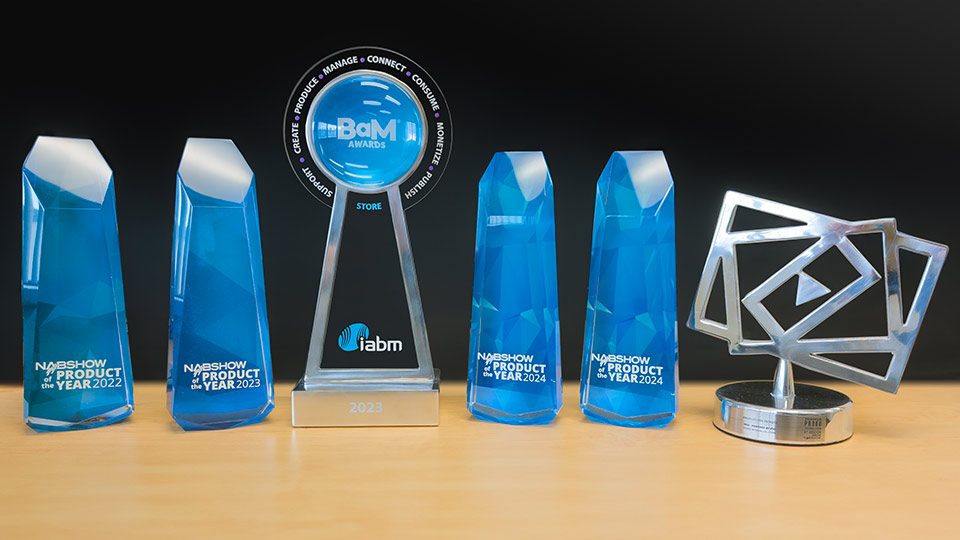 several media technology industry awards on wooden table